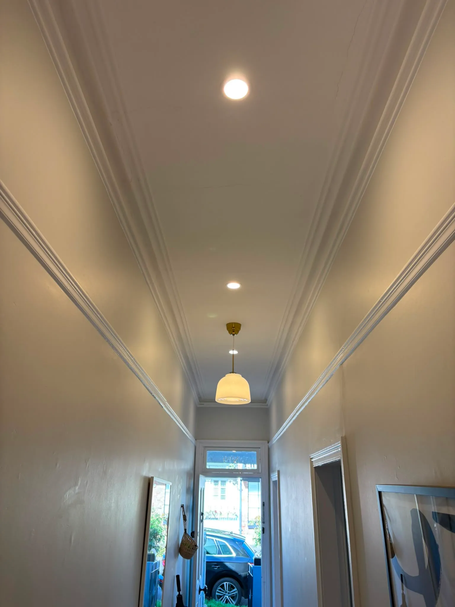 Hallway with brass pendant light and recessed LED downlights in the ceiling